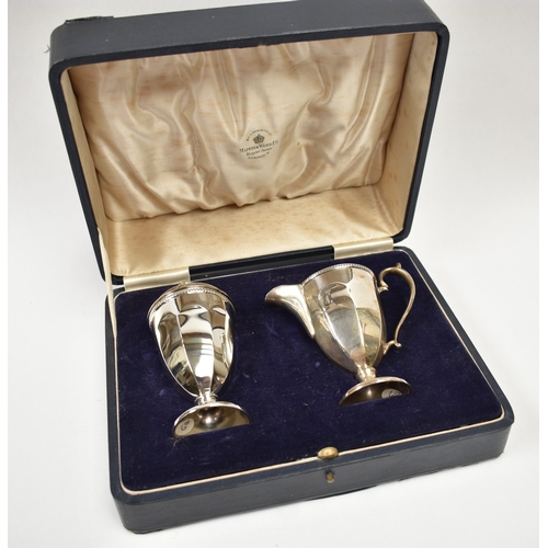 8038 - A George V Mappin & Webb silver sugar castor and cream jug, each of pedestal panelled conical form. ... 