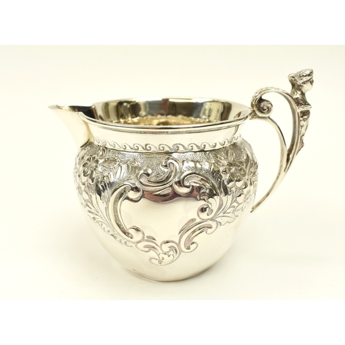 8017 - A Roberts & Belk silver cream jug with figural c-scroll handle, floral spray detail, Sheffield 1902,... 