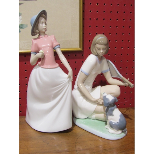4022 - Four Nao figures including a girl with tennis racket and dog and a girl with bird