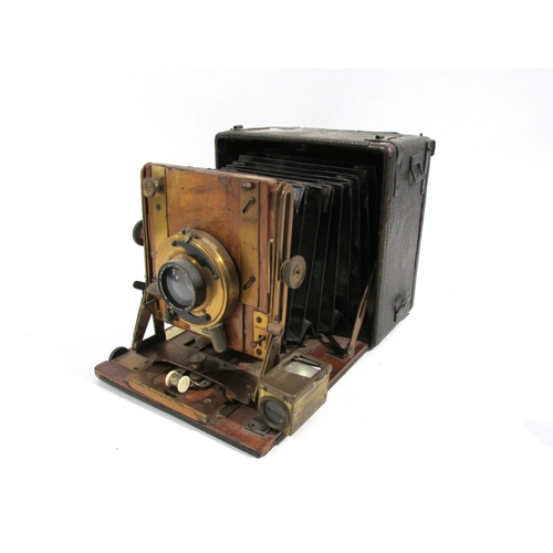 7008 - An early 20th Century Sanderson of London Hand and Stand quarter-plate camera with black bellows, se... 