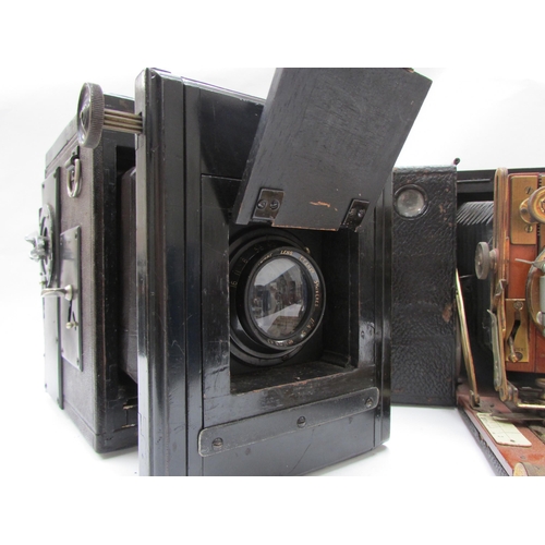 7011 - A Sanderson Hand and Stand plate camera with brass fittings and mahogany body, housed in a black lea... 