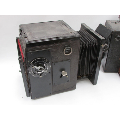 7011 - A Sanderson Hand and Stand plate camera with brass fittings and mahogany body, housed in a black lea... 