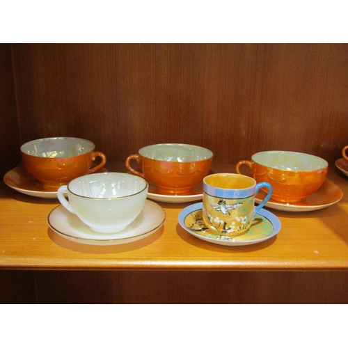 1035 - Six Arcopal vaseline glass and gilt tea cups and saucers, eight orange lustre ware tea cups and seve... 