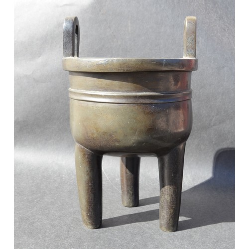 7001 - A bronze 18thc Chinese silver inlaid twin handled tripod ding (censer) profusely inlaid arcahaic sty... 