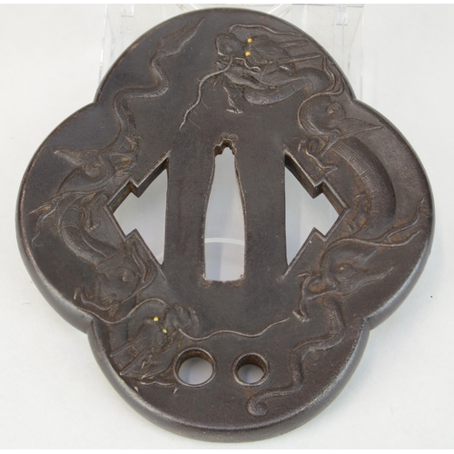 7012 - An iron mokko gata tsuba decorated in relief with dragons with gold eyes, the other side decorated w... 