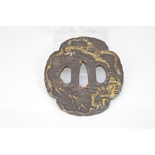 7026 - An iron mokko gata tsuba decorated in takazogan gilt work on one side with a tiger in bamboo, the ot... 