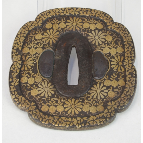 7033 - An iron tsuba a varient of the mokko gata shape, inlaid in hirazogan with gold flowers and foliage, ... 