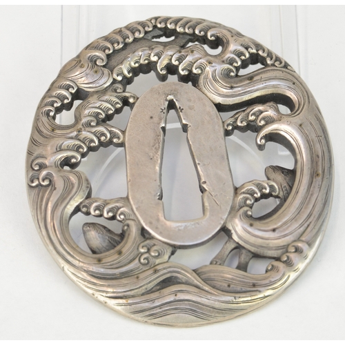 7034 - A silver carved and pierced tsuba decorated with hares leaping through waves, unsigned

 Henry Potte... 