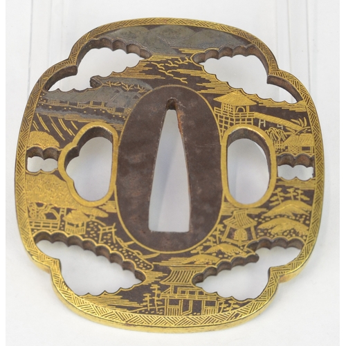 7035 - A mokko gata pierced tsuba decorated in hirazogan with mountains and houses in gold, bearing seal ma... 