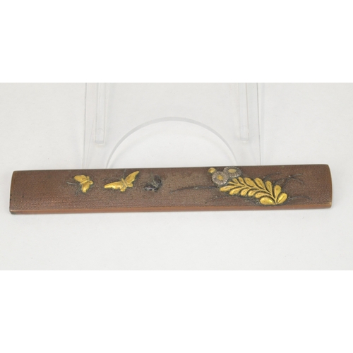 7051 - A copper kozuka decorated in takazogan with gold and shakudo butterflies on nanako ground, unsigned
... 