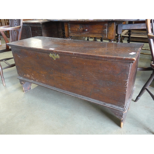 2003 - An 18th Century elm six-plank coffer, with hinged top above plain front panel, raised on bracket fee... 
