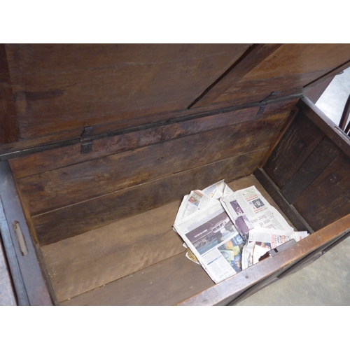 2010 - A circa 17th Century joined oak coffer, with four panel front and hinged plank top, split to top
