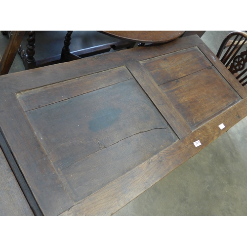 2010 - A circa 17th Century joined oak coffer, with four panel front and hinged plank top, split to top