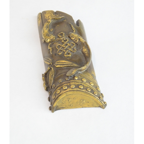 7006 - A Chinese bronze scroll weight decorated with two Buddhist symbols, the endless knot, two golden fis... 