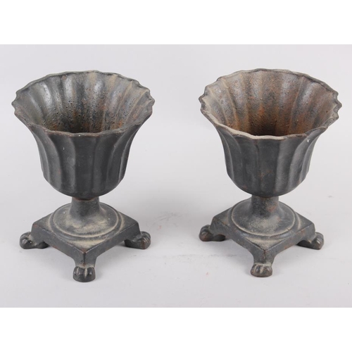 125 - A pair of cast metal campana urns with flared rims, on square base with paw supports, 6 1/2