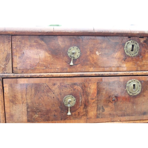 517 - A George III walnut and banded chest of four graduated long drawers with brass drop handles, on turn... 