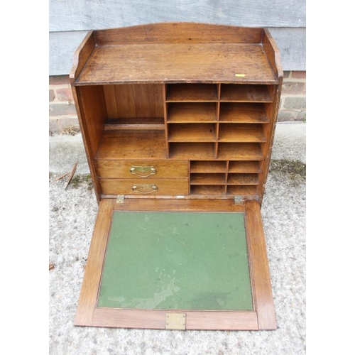 519 - A late 19th century oak fall front writing cabinet with baize-lined slope, drawers and pigeon holes,... 