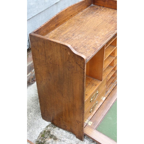 519 - A late 19th century oak fall front writing cabinet with baize-lined slope, drawers and pigeon holes,... 