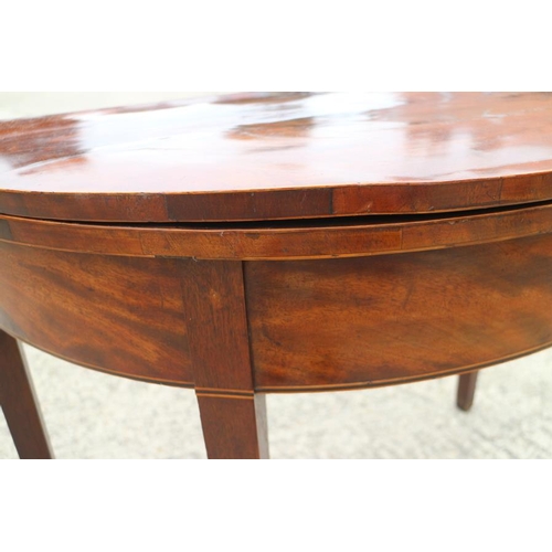 567 - A 19th century semicircular mahogany fold-over top card table, on square taper supports, 36