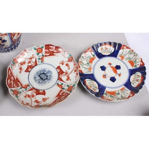 60 - Six Imari plates of various designs, and a similar pair of vases (one with cover missing)