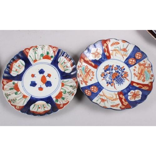 60 - Six Imari plates of various designs, and a similar pair of vases (one with cover missing)