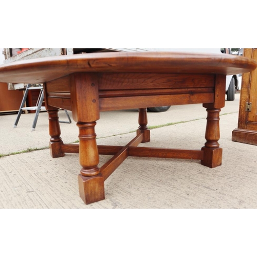 667 - An oak circular low coffee table, on turned and stretchered supports, 48