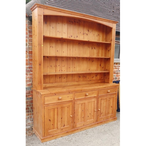 689 - A waxed pine dresser with plate shelves over three drawers and cupboards, on block base