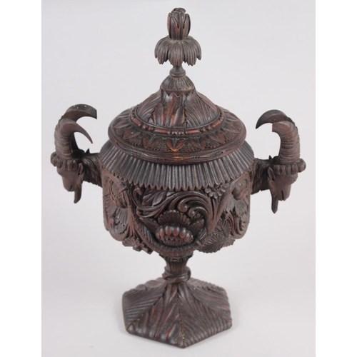 150 - A carved softwood urn and cover with acanthus decoration and goat's head handles, 12