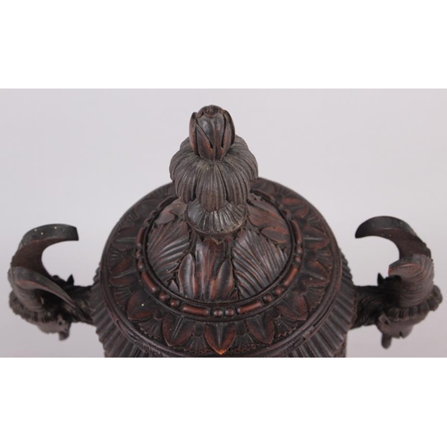 150 - A carved softwood urn and cover with acanthus decoration and goat's head handles, 12