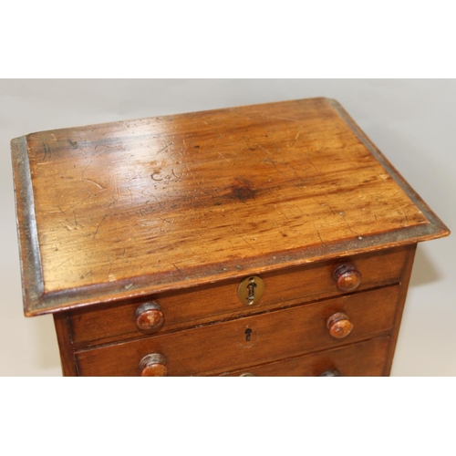 153 - A walnut miniature chest of four long graduated drawers with brass mounted locks (one missing), on b... 