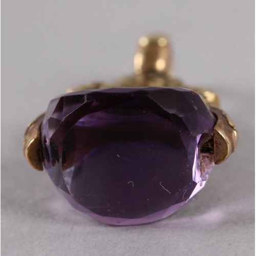 375 - A 19th century yellow metal and amethyst fob spinner with floral decoration