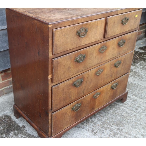 560 - A late Georgian walnut and banded chest of two short and three long drawers with brass handles, on b... 