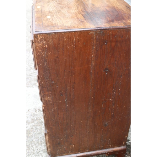 560 - A late Georgian walnut and banded chest of two short and three long drawers with brass handles, on b... 