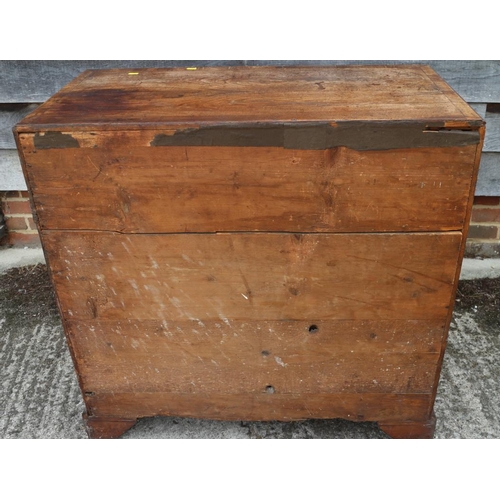 560 - A late Georgian walnut and banded chest of two short and three long drawers with brass handles, on b... 