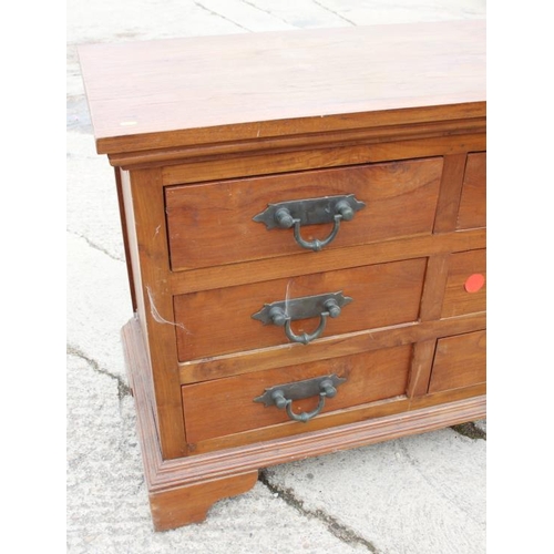 643 - An Oriental hardwood chest of nine drawers with heavy brass handles, on bracket feet, 71