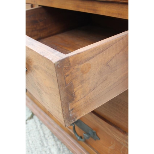 643 - An Oriental hardwood chest of nine drawers with heavy brass handles, on bracket feet, 71