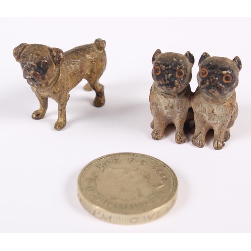 110 - An Austrian miniature cold painted bronze model of a standing pug and a similar pair of seated pugs