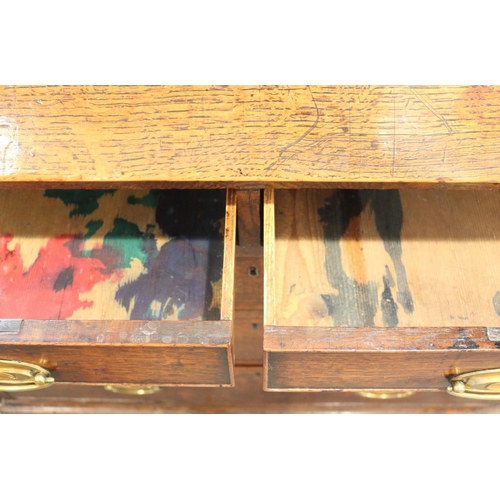 503 - A Georgian provincial oak fall front bureau with fitted interior, drawers and pigeonholes over two s... 