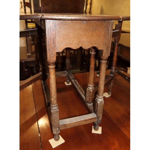 509 - An 18th century oak provincial drop leaf occasional table, on turned and stretchered gate leg suppor... 