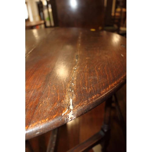 509 - An 18th century oak provincial drop leaf occasional table, on turned and stretchered gate leg suppor... 