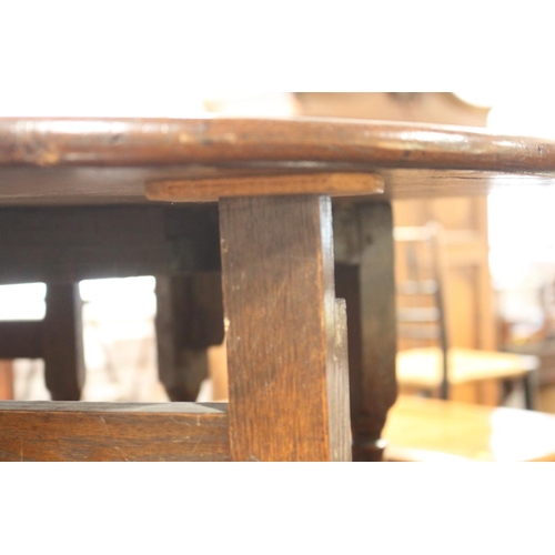 509 - An 18th century oak provincial drop leaf occasional table, on turned and stretchered gate leg suppor... 