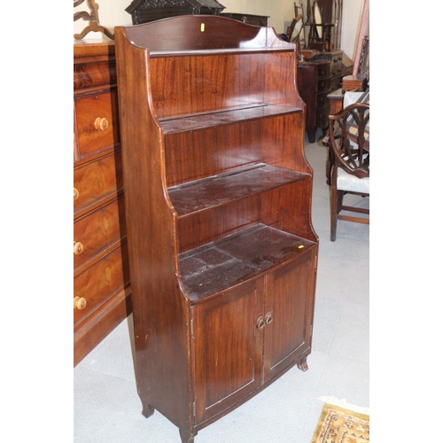 653 - A mahogany bowfront waterfall bookcase over cupboard, 27