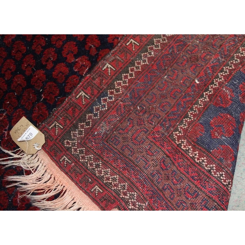 690 - A Middle Eastern geometric design rug on a red ground with multi-borders in shades of blue, 63