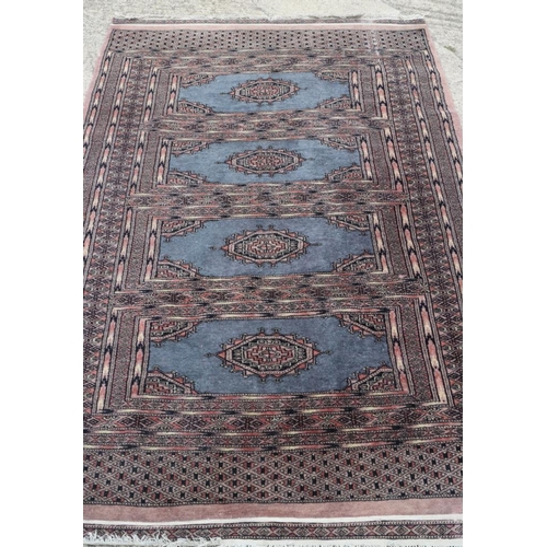 699 - A Bokhara rug with four panels on blue ground, 49