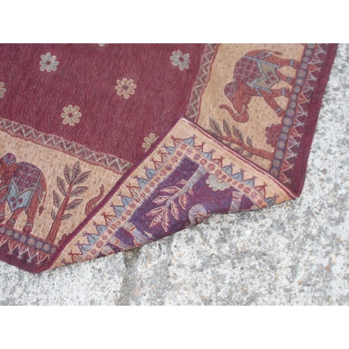 698 - A tapestry rug with elephant design in shades of red and fawn, 68