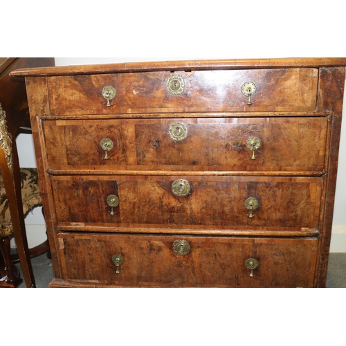 517 - A George III walnut and banded chest of four graduated long drawers with brass drop handles, on turn... 