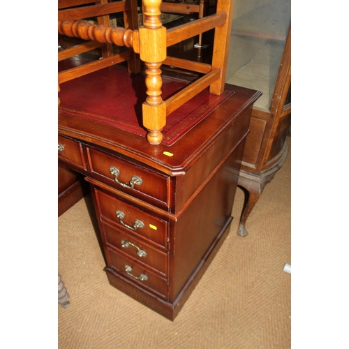 617 - A mahogany serpentine front pedestal desk with tooled leather top, fitted nine drawers, on block bas... 