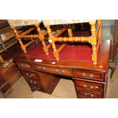 617 - A mahogany serpentine front pedestal desk with tooled leather top, fitted nine drawers, on block bas... 