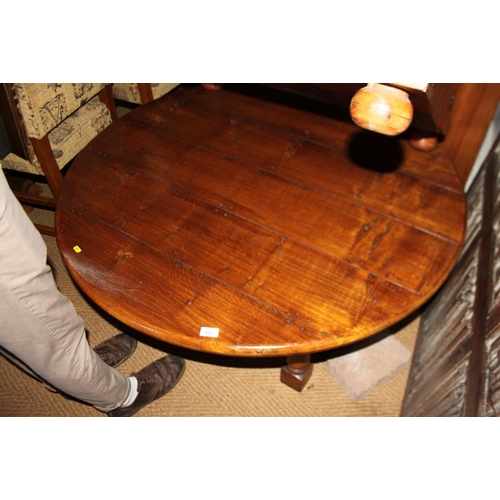 667 - An oak circular low coffee table, on turned and stretchered supports, 48