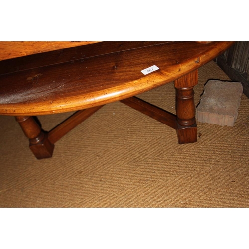 667 - An oak circular low coffee table, on turned and stretchered supports, 48